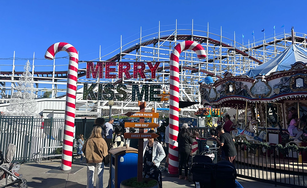 Rollercoast entrance during Christmas at Belmont park with a sign that says "Merry Kiss Me"