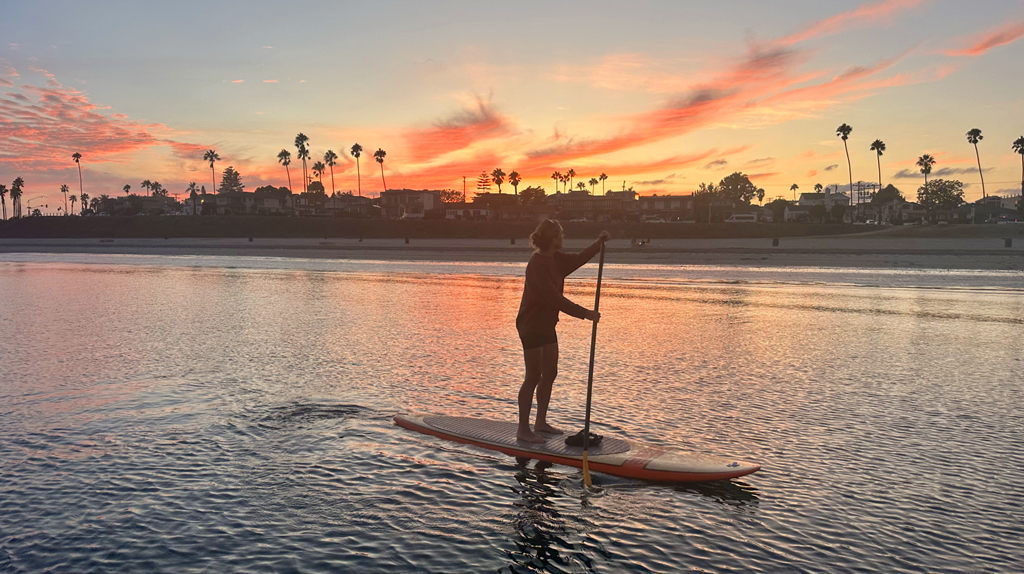 Stand-up paddleboarding in Mission Bay during the sunset